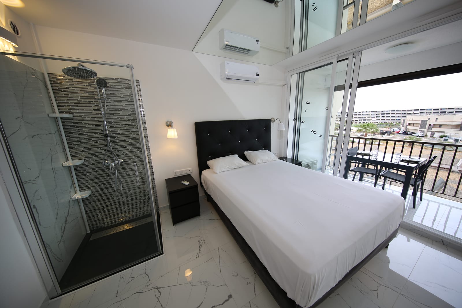 Studio Indecent Cap d'Agde — chambre principale avec douche ouverte et balcon